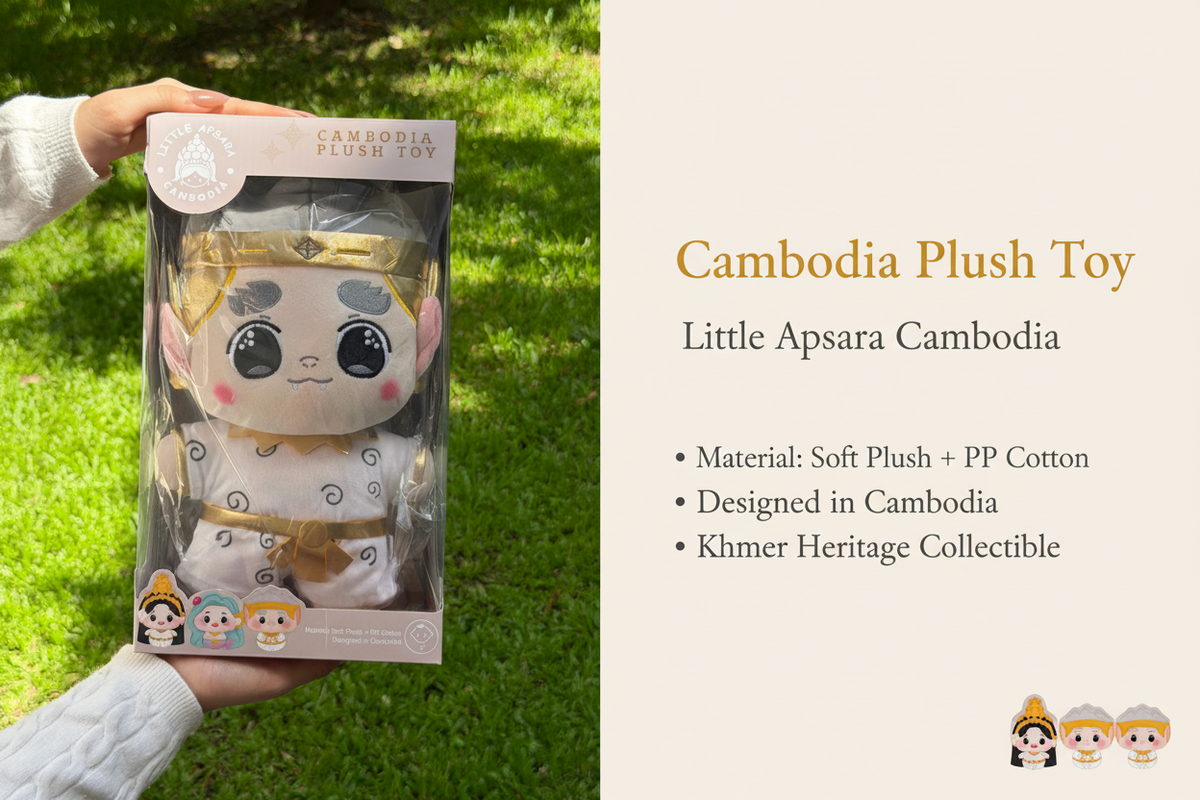 A packaged plush toy held by two hands outdoors on a grassy lawn. The toy is inside a clear plastic blister pack with a printed cardboard backing that reads 'CAMBODIA PUREST TOY' and shows cartoon-style character graphics.